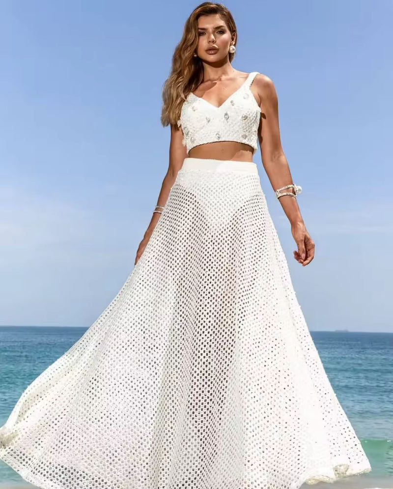 Side view of model in Amira beach set with sheer mesh wrap skirt and bikini at the seaside