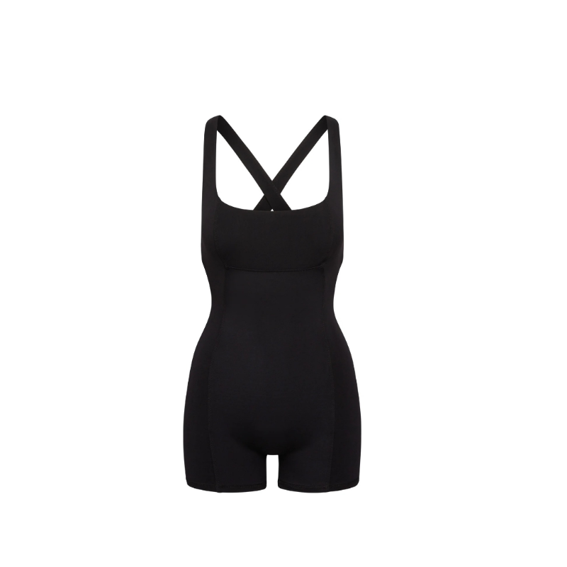 Black sculpting onepiece with cross-back straps and elegant cutout detail, made from a stretchy polyester-elastane blend, ideal for activewear and casual styling.