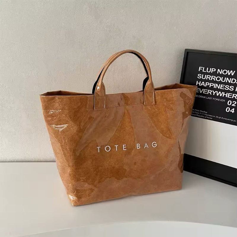 Brown jelly-style PVC tote bag with modern lettering – stylish large shoulder bag for shopping, market days, or moms on the go.