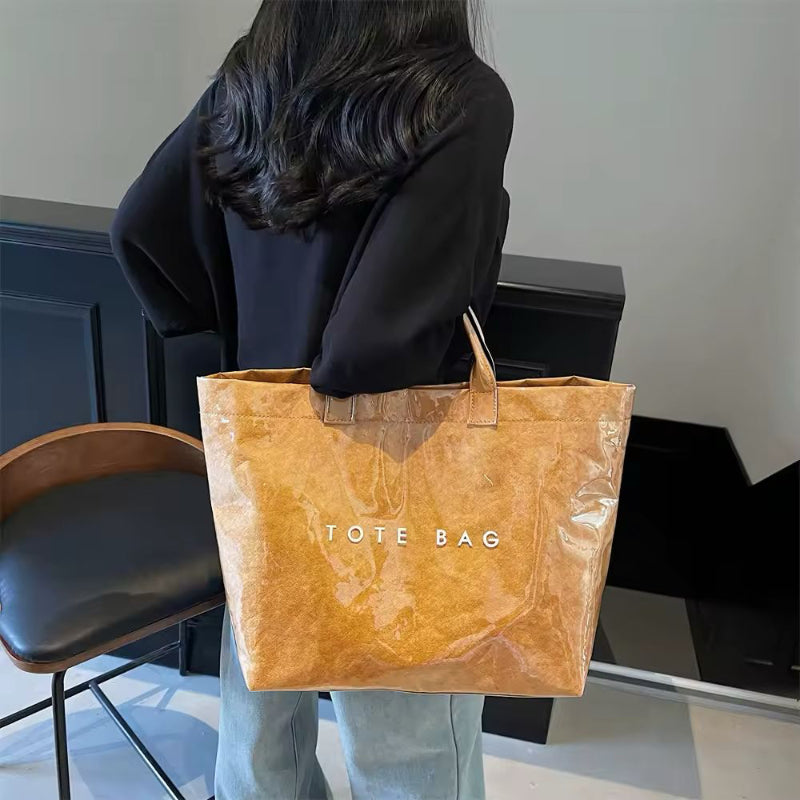 Brown jelly-style PVC tote bag with modern lettering – stylish large shoulder bag for shopping, market days, or moms on the go.