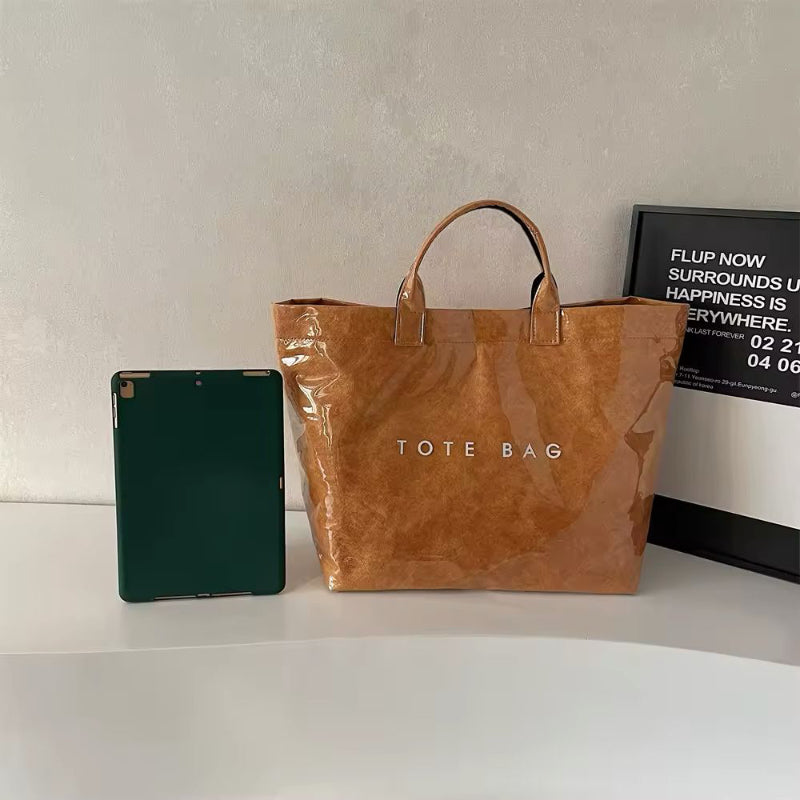Transparent waterproof jelly tote bag in glossy PVC with bold letter print, shown in modern color variations – ideal for beach, city shopping, moms, and travel. Stylish large capacity handbag with short handles.