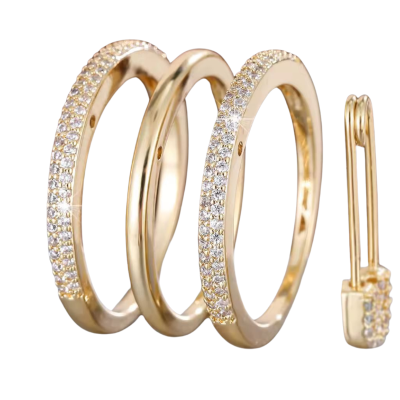 Close-up of luxurious gold-tone ring set with safety pin-style charm and cubic zirconia