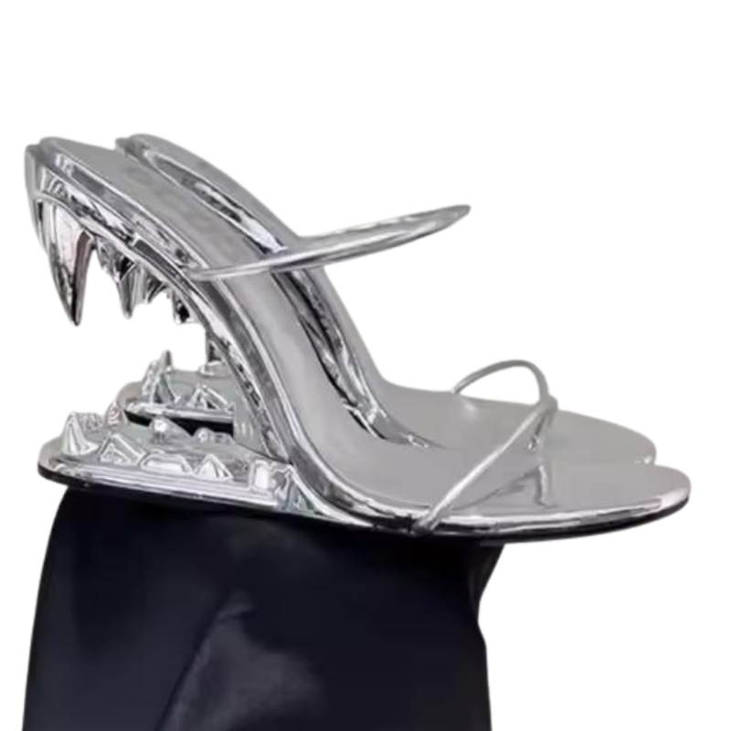 FATAL BITE Heels in Chrome Silver – futuristic high heels with 3D metal shark bite heel, shiny silver sandals for women, edgy designer footwear for summer fashion.