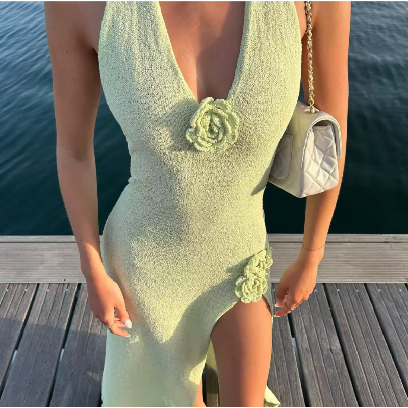Woman wearing mint green floral halter maxi dress with V-neckline and high slit – FLEURIA Summer 2025 collection.