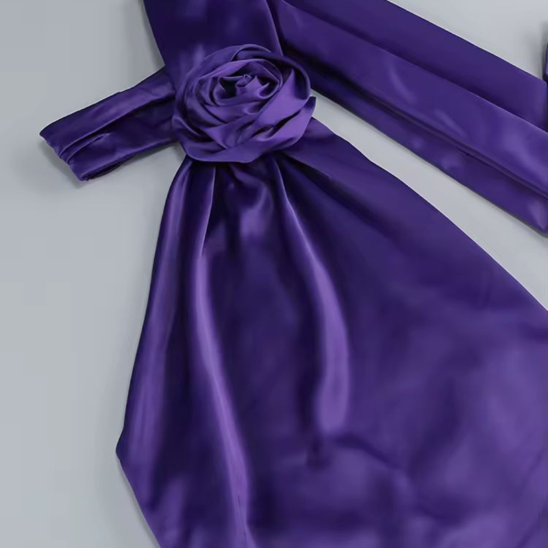 Side profile of woman in glamorous purple evening dress with draped fabric and open back