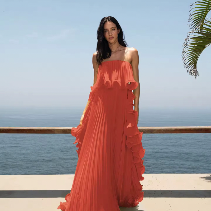 Model walking in long pleated dress – sunset summer fashion inspired by Ibiza style.