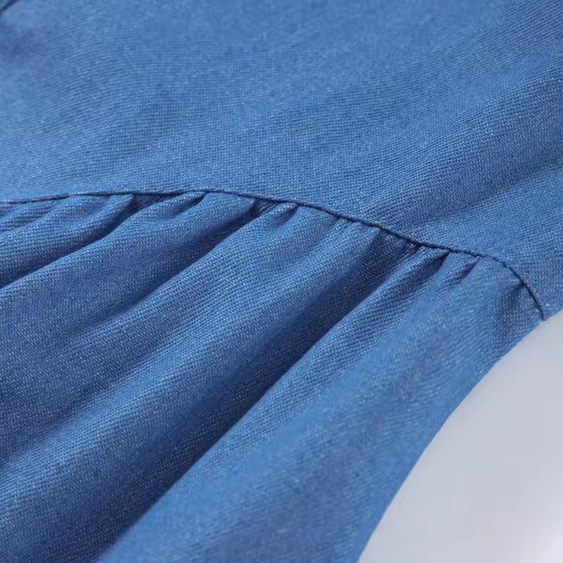 Romantic tie-back detail on open-back denim dress – elegant feminine fashion detail