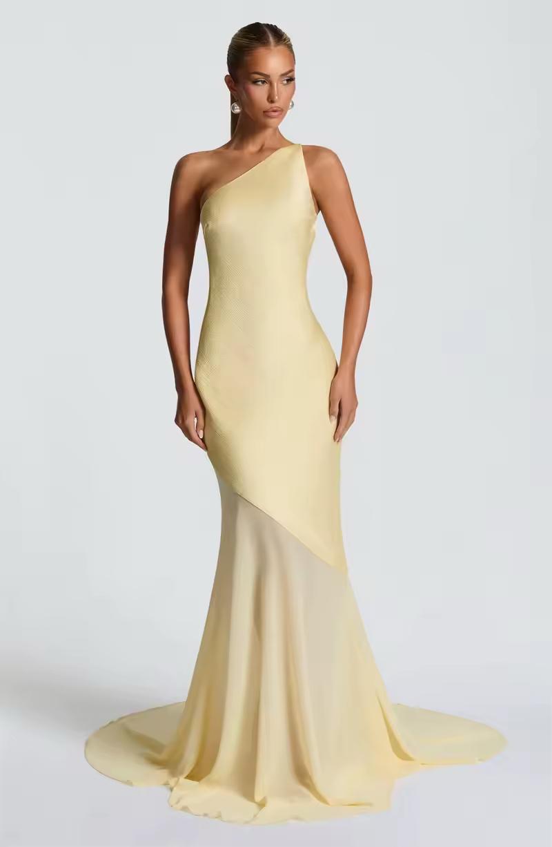 Model wearing champagne yellow formal dress with open back and high slit illusion – resort party outfit