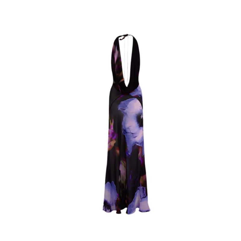 Collage of four images showcasing the “Midnight Bloom” dress. The model wears a backless, deep V-neck floral maxi dress in dark tones with purple, blue, and pink abstract flower prints. Close-up shots highlight the flowy fabric and elegant silhouette. The setting includes minimalist architecture and seaside views.