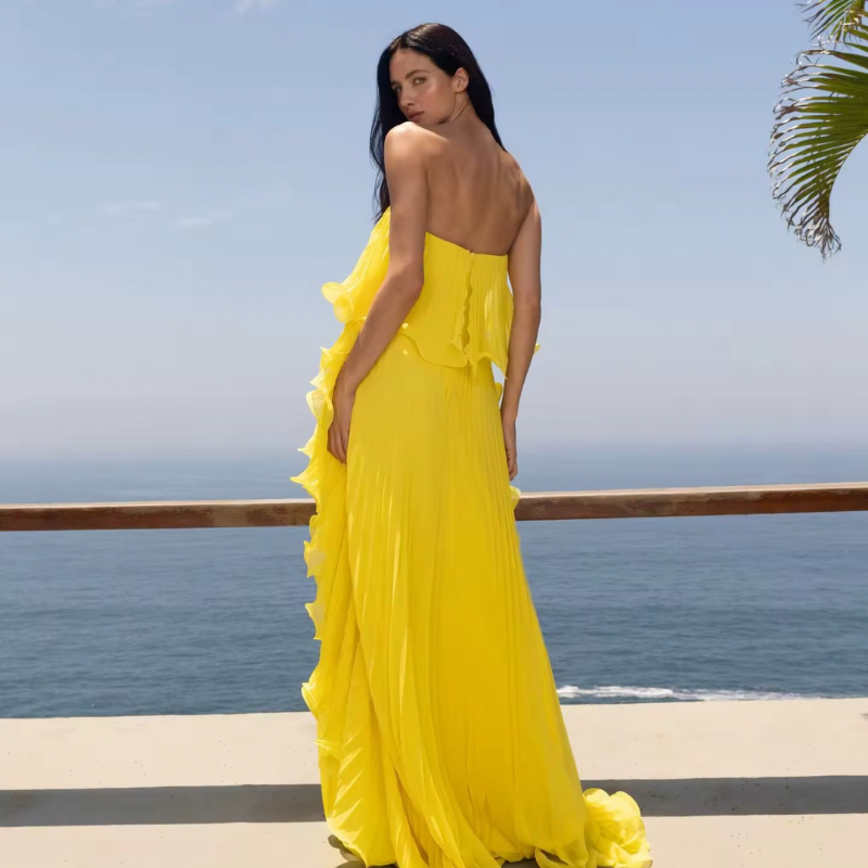 Woman wearing strapless ruffled maxi dress in yellow – Chic & Charm Ibiza Breeze summer collection