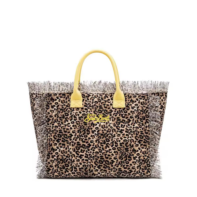 Close-up of thick canvas beach bag with The place to be – Saint Barth” print and raw fringe edges in bohemian summer style.