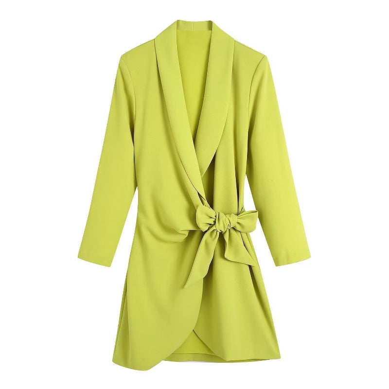 Knee-length neon yellow wrap dress for women styled with a black bag and casual white trainers.