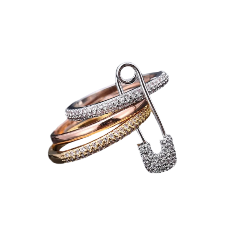Silver triple ring with pave-set zirconia stones and safety pin accent.