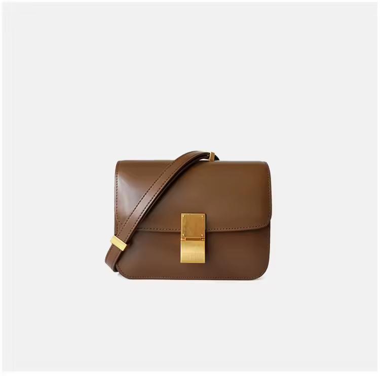 Classic cognac brown leather shoulder bag with gold clasp and soft texture — warm-toned minimalist leather accessory for fall and winter.