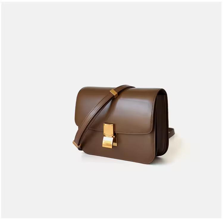 Classic cognac brown leather shoulder bag with gold clasp and soft texture — warm-toned minimalist leather accessory for fall and winter.