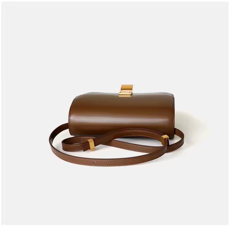 Classic cognac brown leather shoulder bag with gold clasp and soft texture — warm-toned minimalist leather accessory for fall and winter.