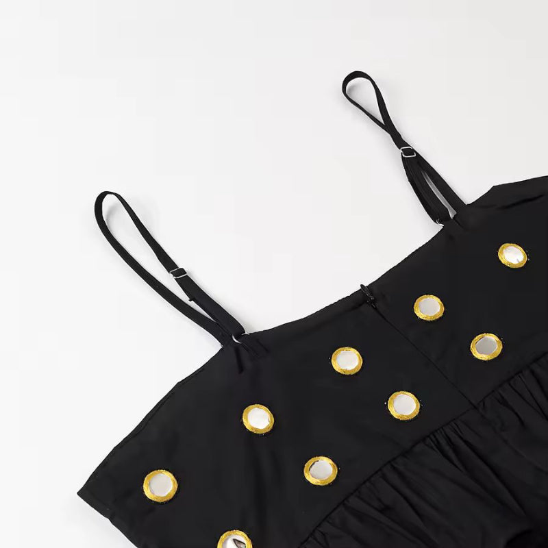 Detail shot of black mini skirt with metallic ring embellishments and soft fabric