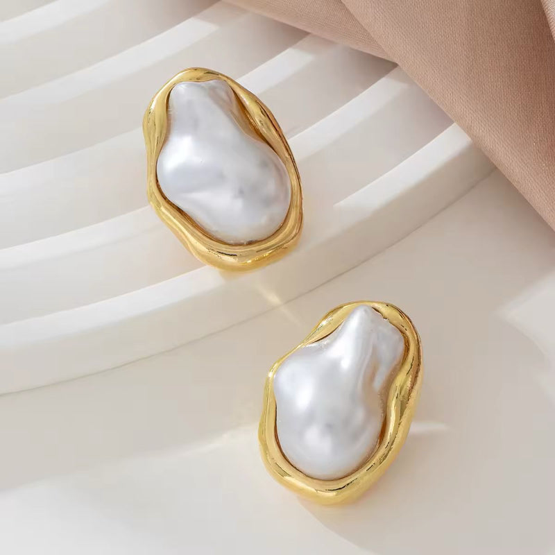 ZAYA gold pearl earrings – sculpted baroque-style faux pearl studs on soft satin background
