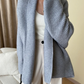 Model wearing an oversized cardigan in warm gray, showcasing its relaxed fit and cozy style.