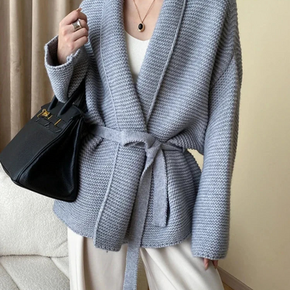 Model wearing an oversized cardigan in warm gray, showcasing its relaxed fit and cozy style.