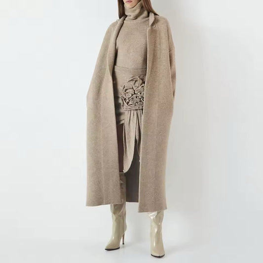 Elegant women’s knitwear set in beige – long wool blend coat, turtleneck sweater and midi skirt with ruffle detail, autumn winter fashion outfit.