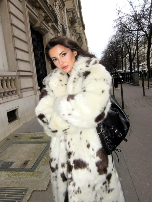 Long white faux fur coat with cow print, stylish women's outerwear, trendy faux fur coat, elegant fashion statement, chic casual coat, sustainable women's fashion, versatile winter coat.