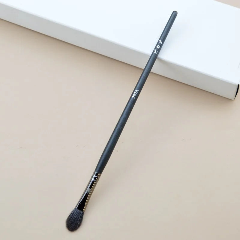 Makeup brush with an elegant design featuring a wooden handle and high-quality hairs for perfect makeup applications. Ideal for blusher, concealer, and eyeshadow.