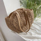 Handmade round boho straw bag with leather shoulder straps in beige
