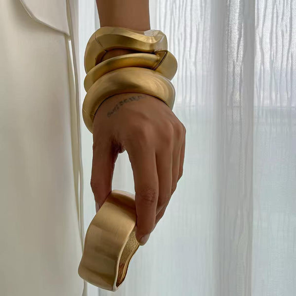 BoldCuff – sculptural matte gold bracelet with wide, architectural design for modern unisex style.”
