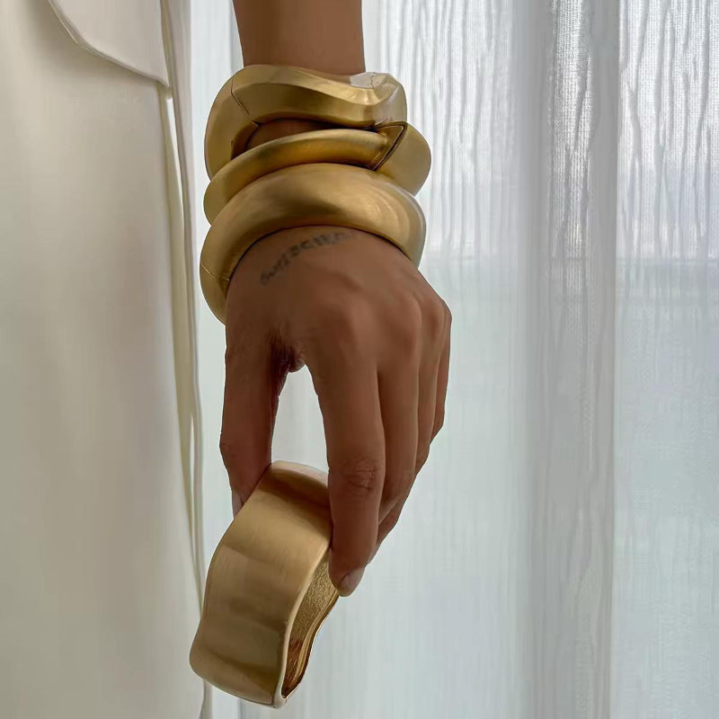 BoldCuff – sculptural matte gold bracelet with wide, architectural design for modern unisex style.”
