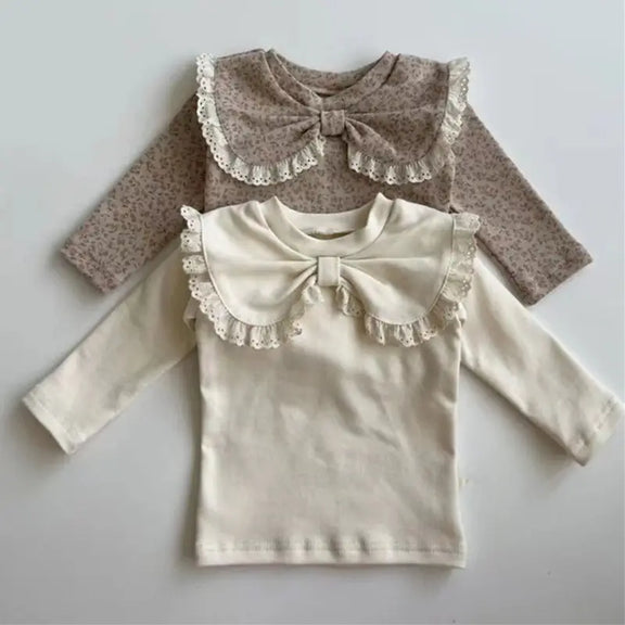 Beige and brown baby tops for girls made from 100% cotton, featuring a decorative bow, lace trims, and floral pattern, perfect for fall fashion and comfortable baby clothing.