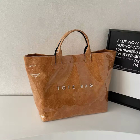 Brown jelly-style PVC tote bag with modern lettering – stylish large shoulder bag for shopping, market days, or moms on the go.