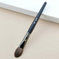 Makeup brush with an elegant design featuring a wooden handle and high-quality hairs for perfect makeup applications. Ideal for blusher, concealer, and eyeshadow.