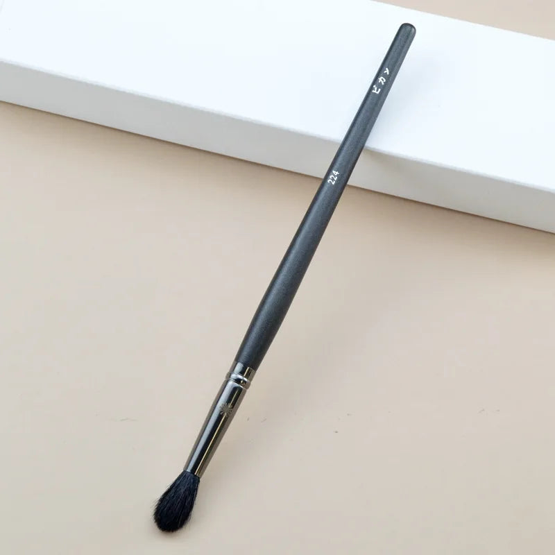 Makeup brush with an elegant design featuring a wooden handle and high-quality hairs for perfect makeup applications. Ideal for blusher, concealer, and eyeshadow.