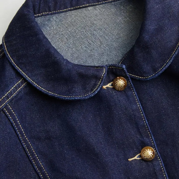 Close-up of button details on a dark blue denim jacket for women