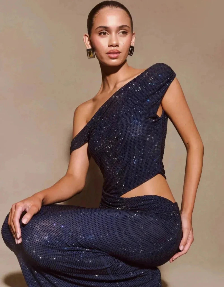 Close-up of navy blue fabric with golden sequin accents, highlighting the luxurious shimmer and smooth texture.

