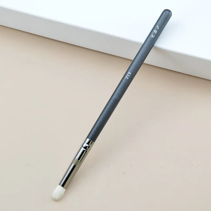 Makeup brush with an elegant design featuring a wooden handle and high-quality hairs for perfect makeup applications. Ideal for blusher, concealer, and eyeshadow.