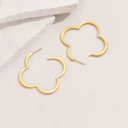 Trendy gold floral statement hoop earrings worn on ear – large clover-shaped copper earrings for women, fashion jewelry 2025
