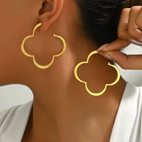 Trendy gold floral statement hoop earrings worn on ear – large clover-shaped copper earrings for women, fashion jewelry 2025
