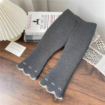 Fashionable flared leggings for girls in cream, made from cotton and spandex with star-shaped embellishments and an elastic waistband for comfort. Trendy kids’ wear for everyday or special occasions.