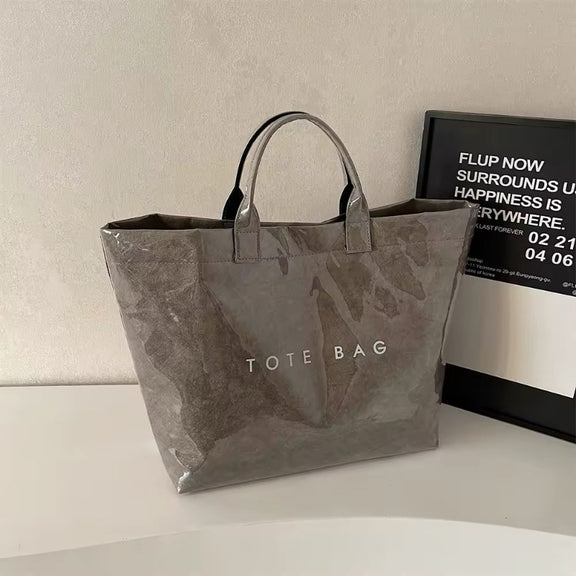 Grey jelly-style PVC tote bag with modern lettering – stylish large shoulder bag for shopping, market days, or moms on the go.