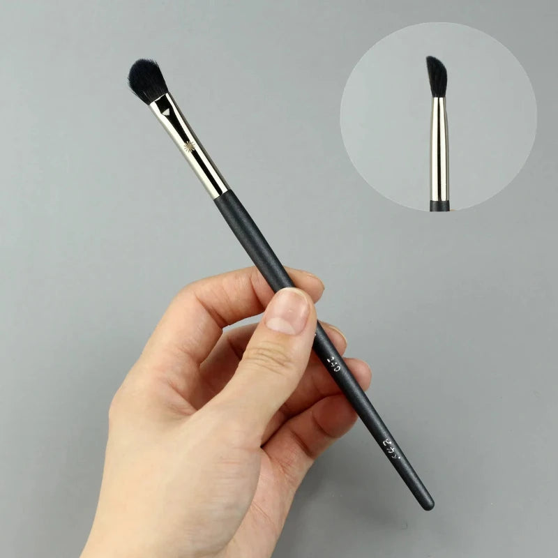 Makeup brush with an elegant design featuring a wooden handle and high-quality hairs for perfect makeup applications. Ideal for blusher, concealer, and eyeshadow.