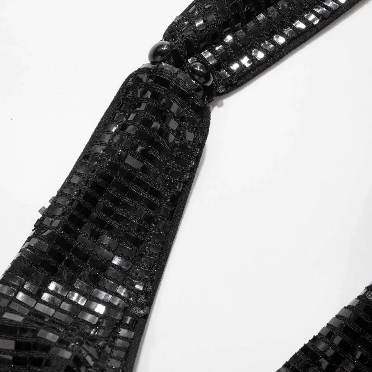 Side view of shimmering black sequin party dress with halter strap and curve-hugging silhouette – backless and bold eveningwear.
