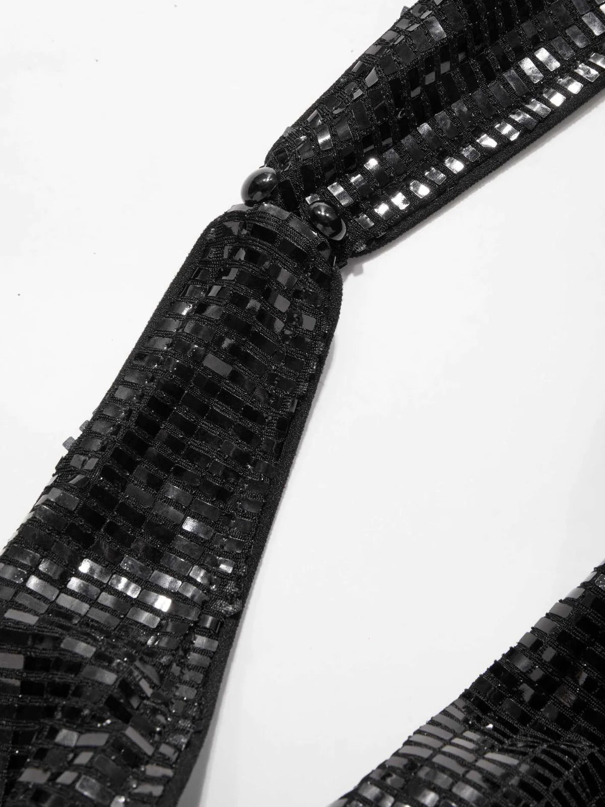 Side view of shimmering black sequin party dress with halter strap and curve-hugging silhouette – backless and bold eveningwear.
