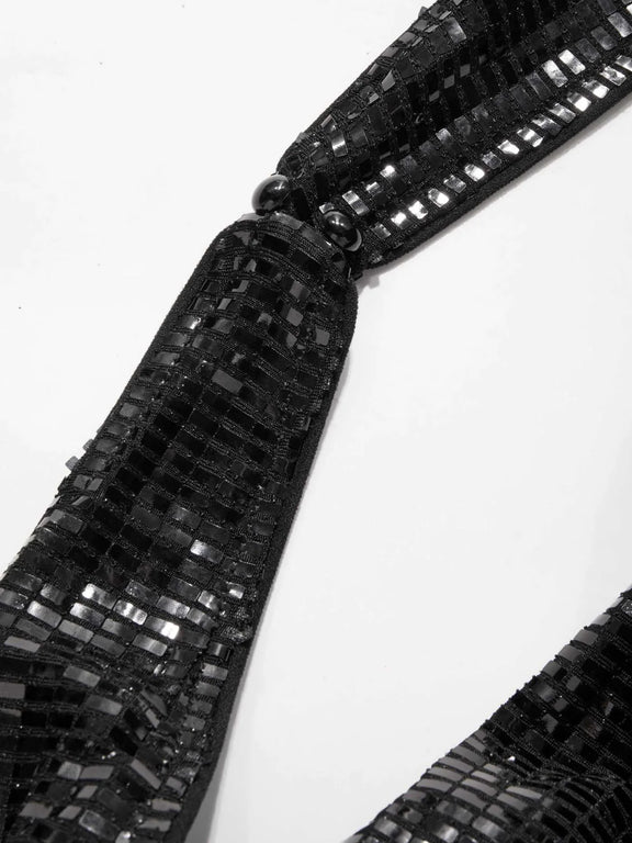 Side view of shimmering black sequin party dress with halter strap and curve-hugging silhouette – backless and bold eveningwear.
