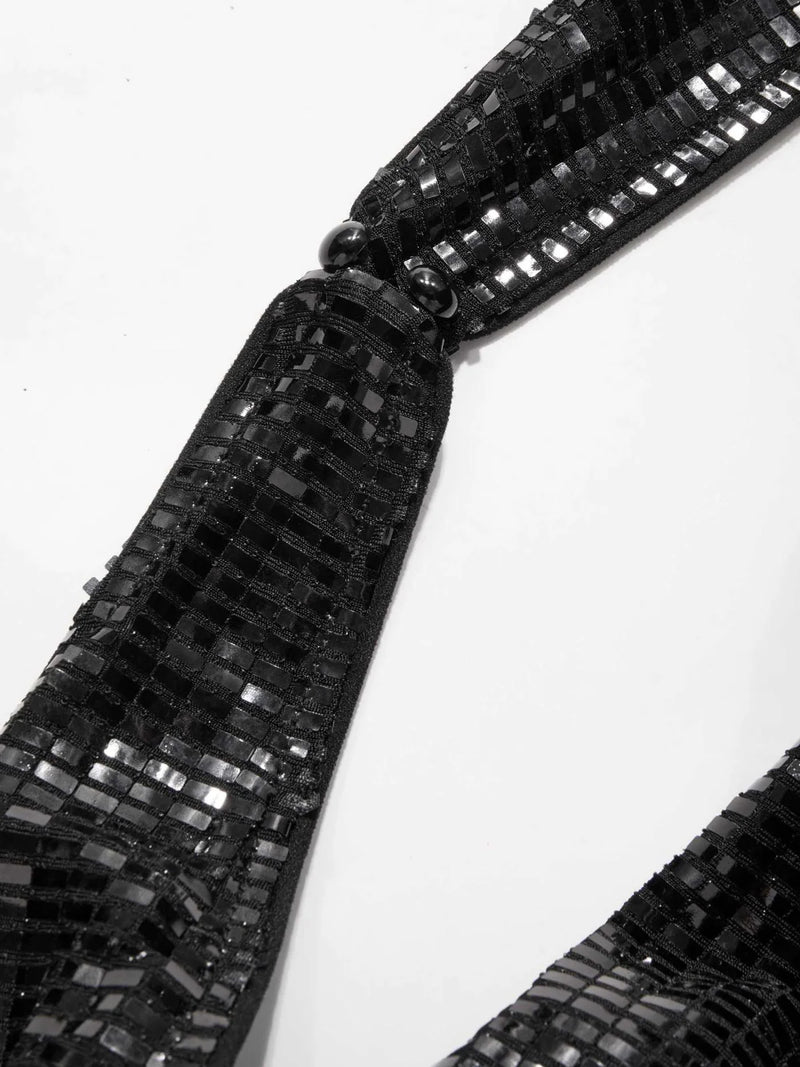 Side view of shimmering black sequin party dress with halter strap and curve-hugging silhouette – backless and bold eveningwear.
