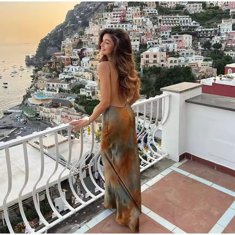 Chic boho-style vacation dress flowing in the breeze with ocean view and palm trees.
