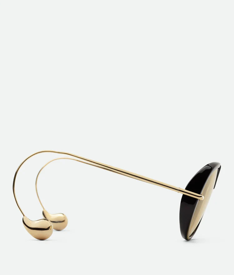 Side view of LAYAH sunglasses with slim gold-tone metal arms and tortoise shell frame.
