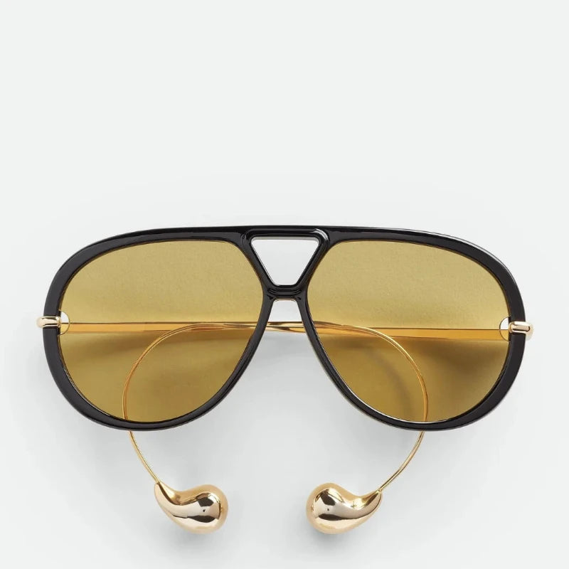 Gold-arm tortoise sunglasses side view, fashion accessory.