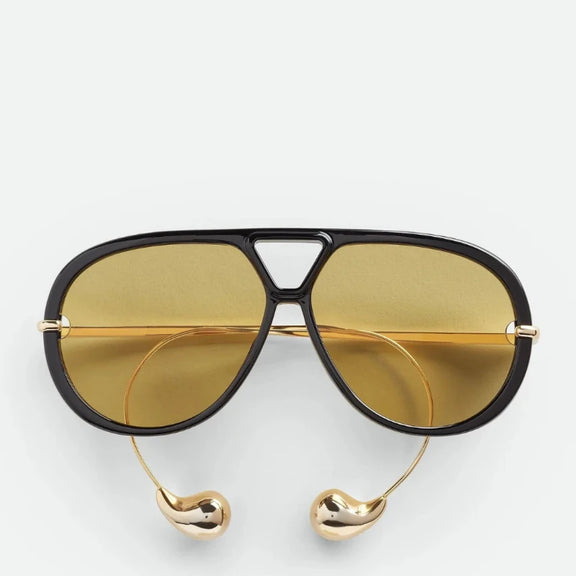 Gold-arm tortoise sunglasses side view, fashion accessory.
